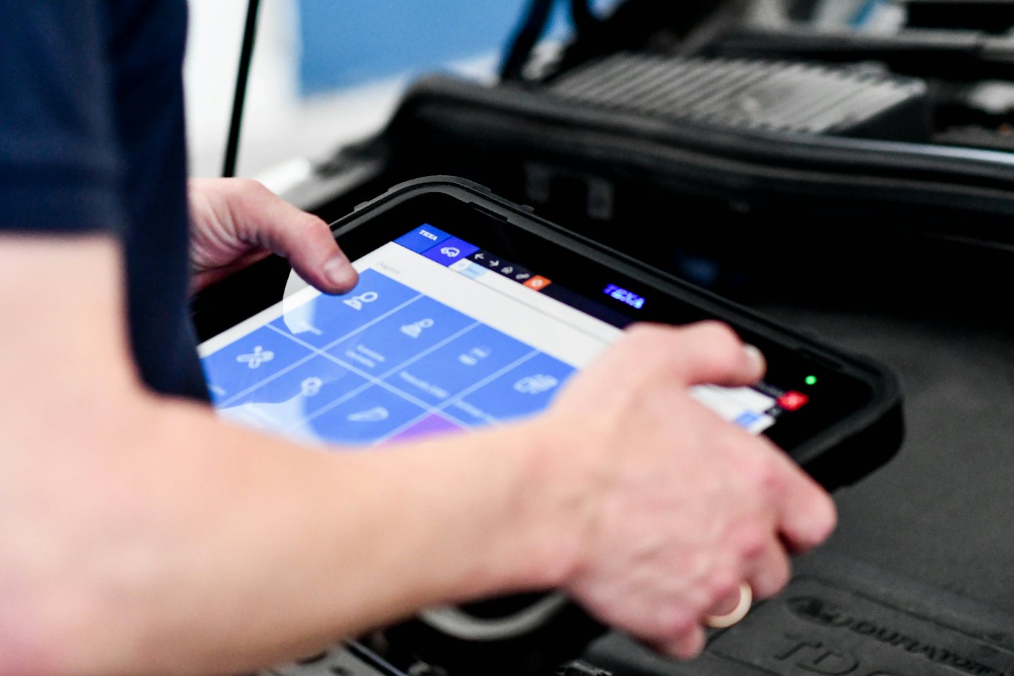 A technician uses a tablet to diagnose an engine.